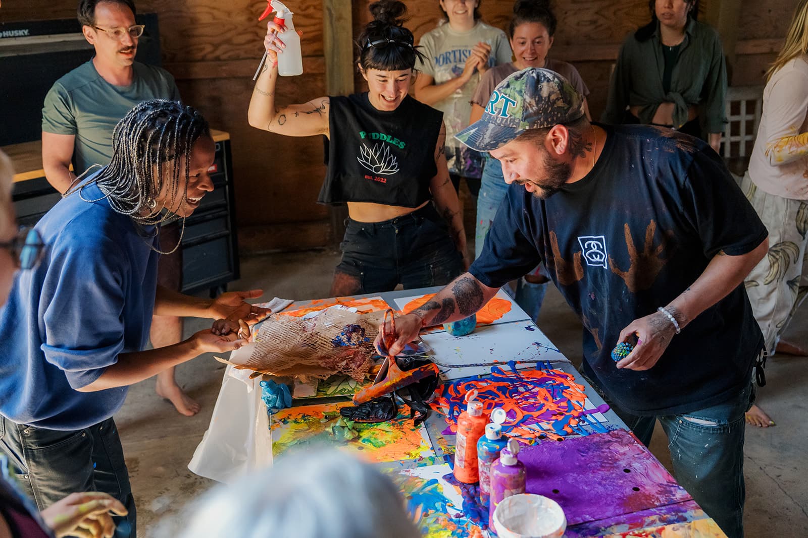 The group laughing while making messy collaborative art