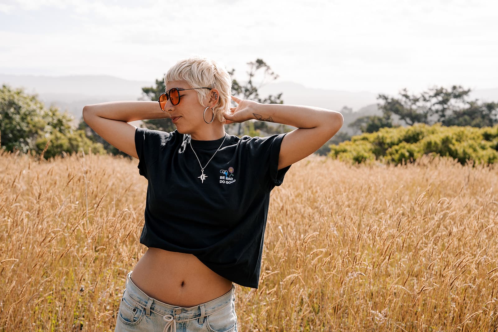 Natural cream tee — woman laughing with arms raised