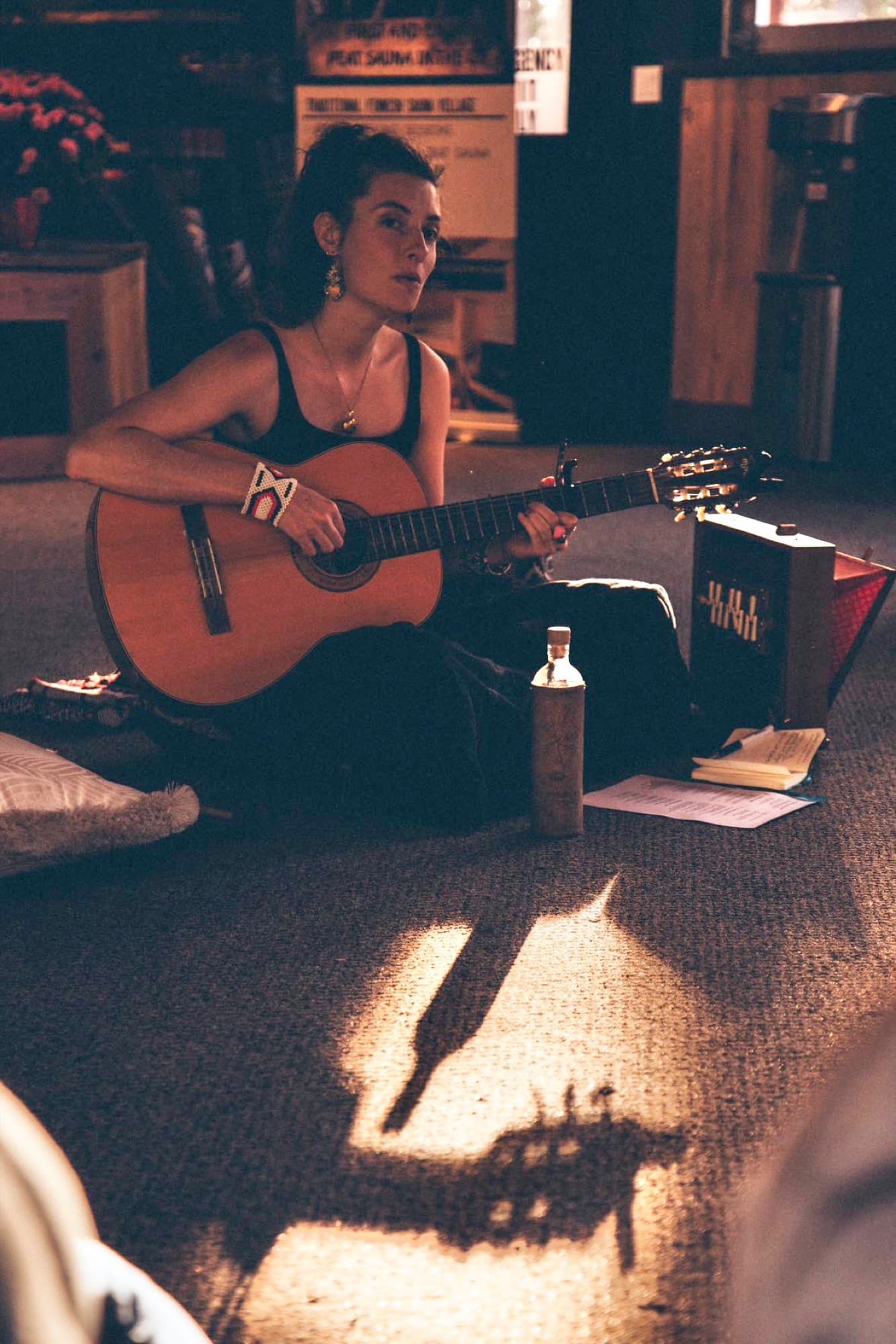 Taylor playing guitar in warm evening light.