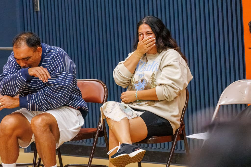 A staff member covering her mouth laughing during the witnessing exercise