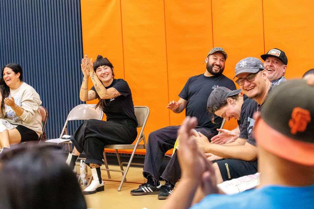 A group of staff clapping and celebrating during the final sharing circle