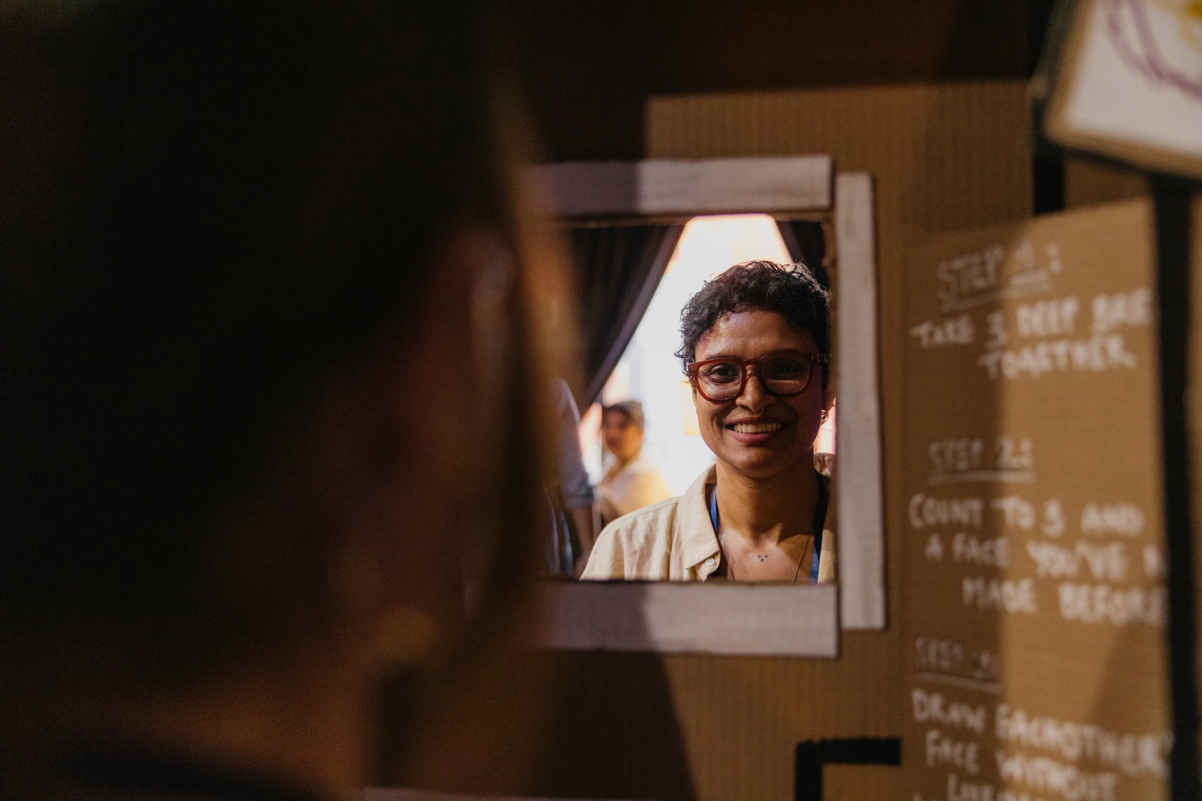 Person smiling while drawing and being drawn in the portrait booth