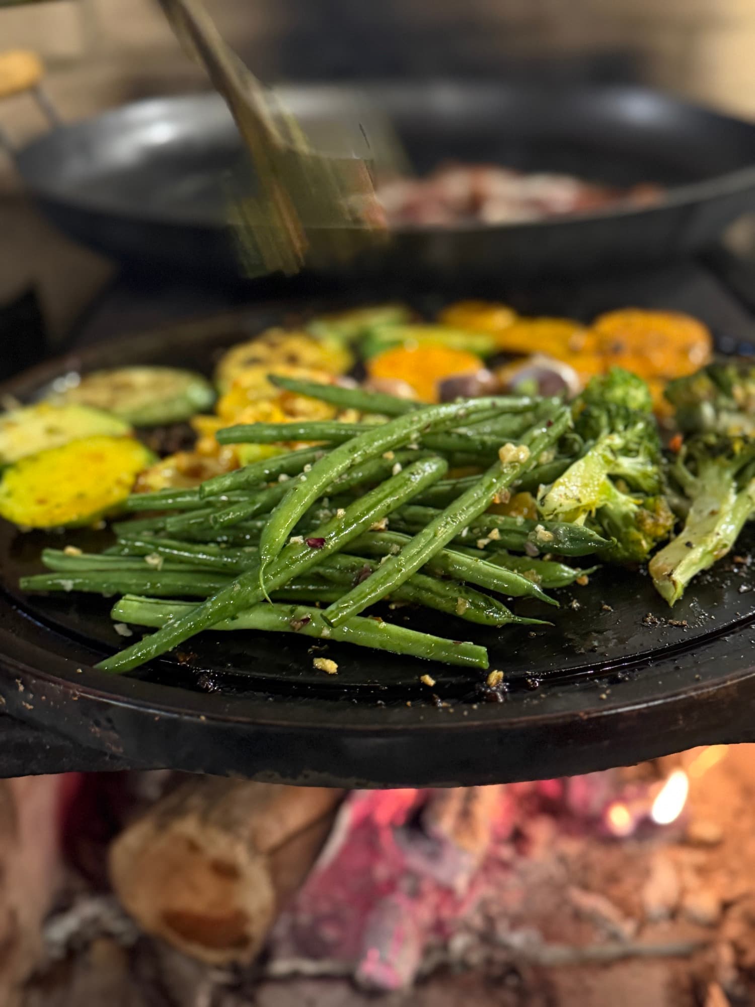 Greens and vegetables grilled over the fire.