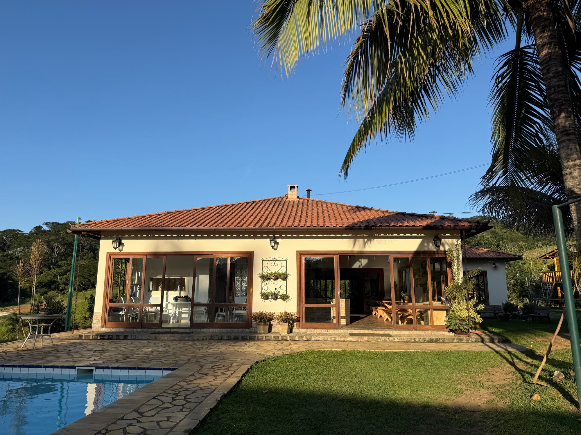 The main farmhouse and pool in golden evening light.