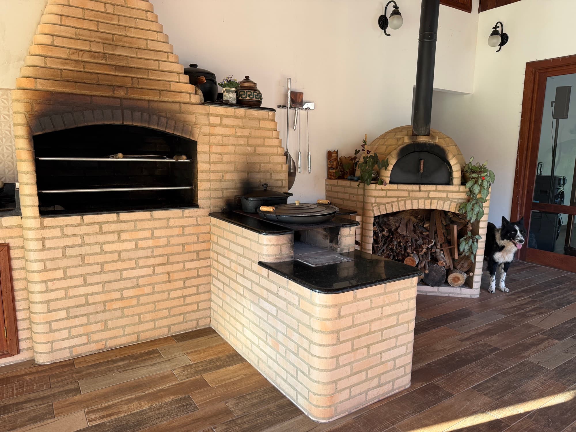 Brick BBQ and wood-fired pizza oven in the outdoor kitchen.
