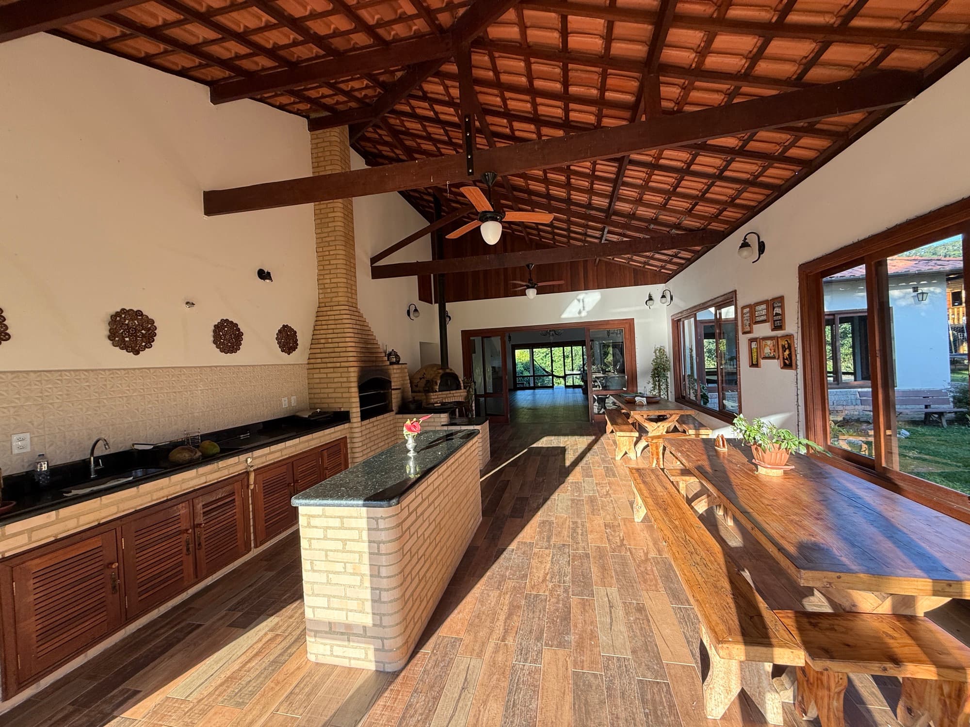 A large kitchen with a long wooden communal table under beamed ceilings.