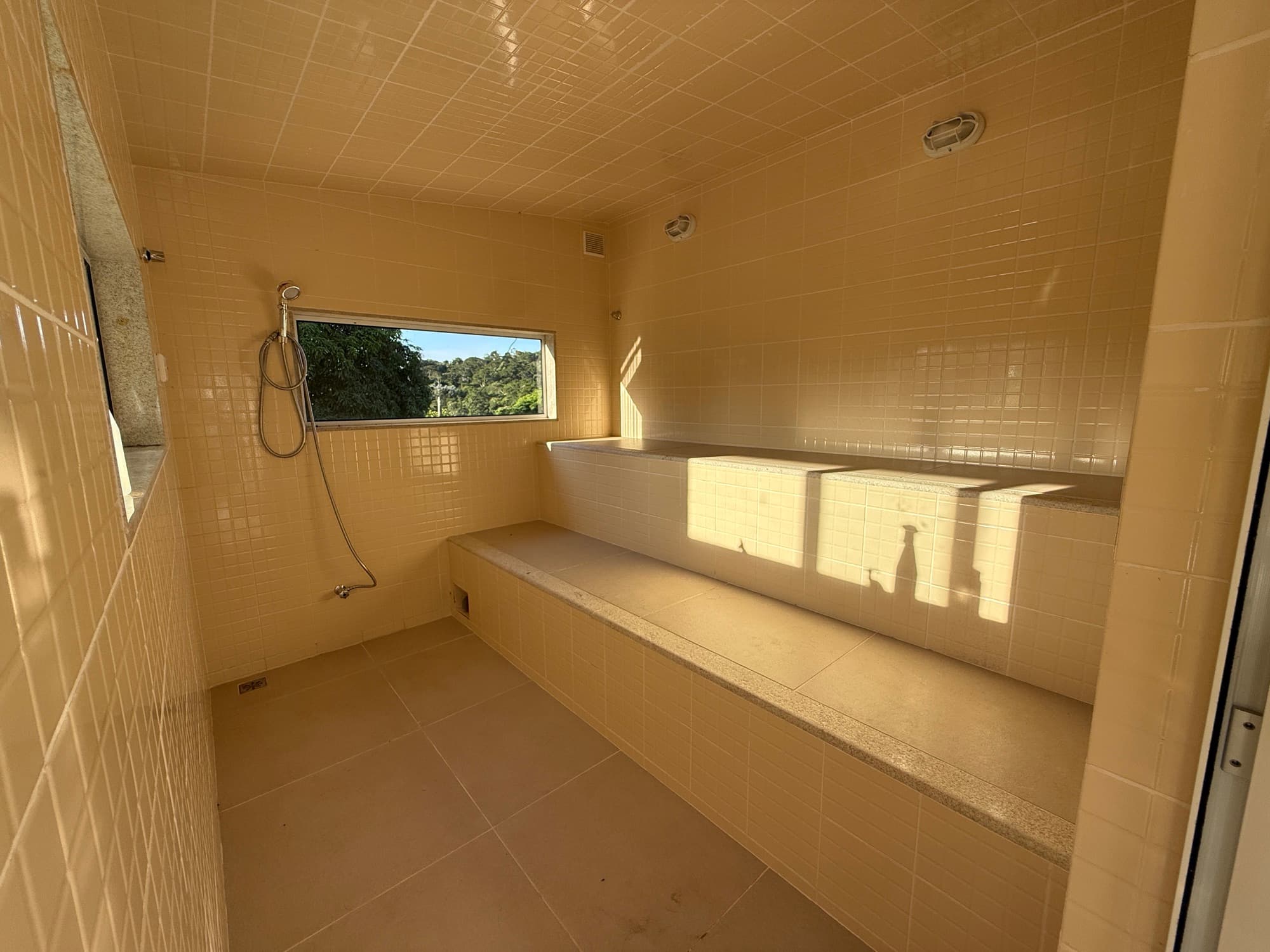 The tiled steam room with a window onto the trees.