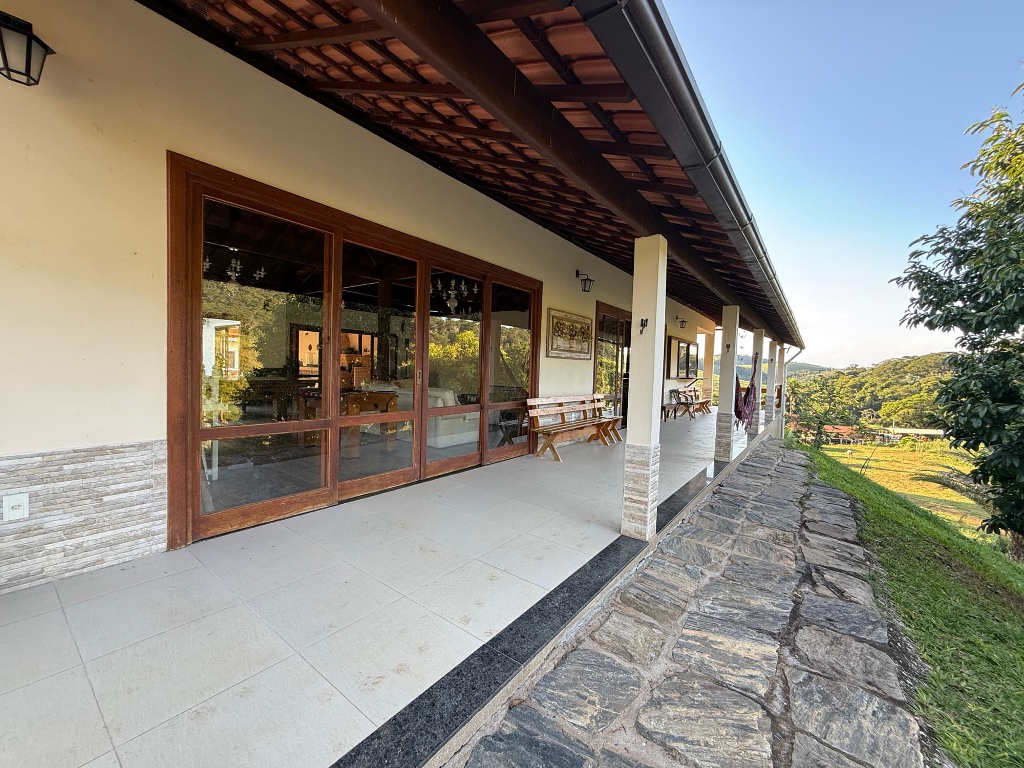 The house's long covered veranda looking out over the green valley.